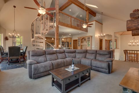 - Spacious living room with vaulted ceilings  
- Cozy sectional seating for groups  
- Spiral staircase adds rustic charm