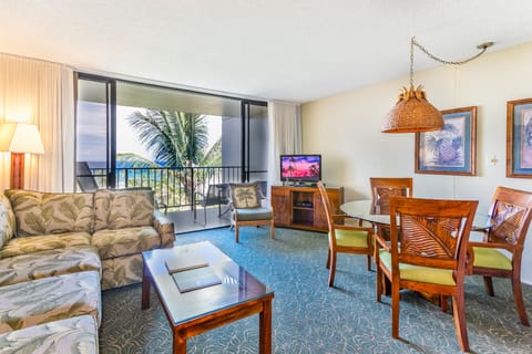 Open living and dining space with tropical decor, ocean views from your private balcony, and a cozy setup perfect for relaxing after a day at the beach.