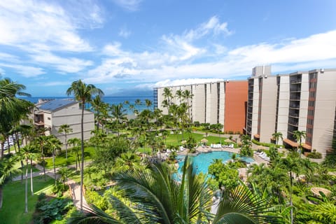A tropical resort property with lush gardens, sparkling pool, and oceanfront location under sunny Hawaiian skies.