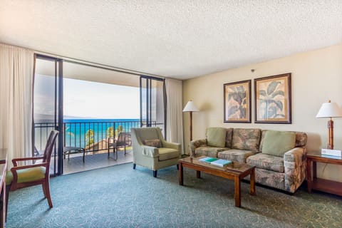 Settle into your cozy living room where tropical comfort meets breathtaking ocean views. Step through the sliding doors to your private balcony and soak in the turquoise waters stretching to the horizon.