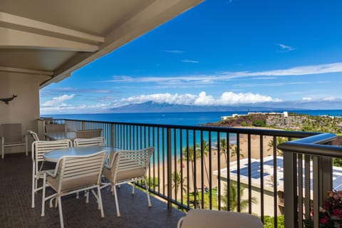 Sip your morning coffee on your private balcony overlooking the sparkling ocean, with stunning island and mountain views stretching to the horizon beneath brilliant blue skies.