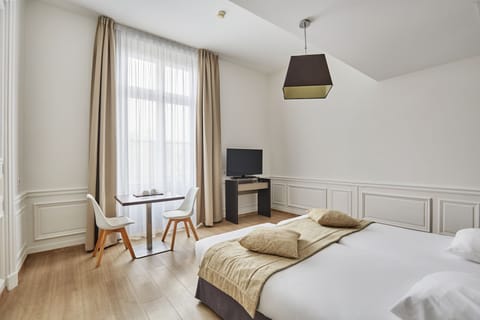 Refined double room with classic wall paneling, large windows, and an inviting, restful atmosphere.