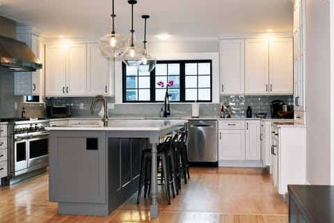 Chef kitchen with seating for four at counter.