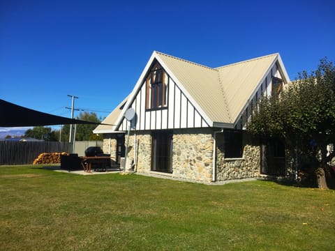 Back garden - fully fenced with BBQ  and seating area on patio under a shade net
