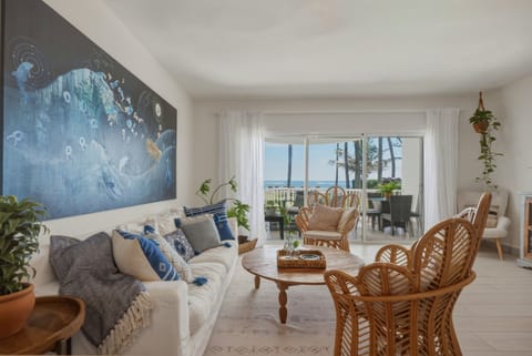 A bright, open living room filled with natural light and beach energy. Comfortable, welcoming, and designed to relax after a day in the sun.