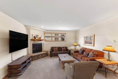 Settle into your cozy living room with plush seating, warm fireplace, and large TV for perfect mountain retreat evenings.