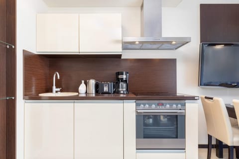 Kitchenette with oven and refrigerator. 