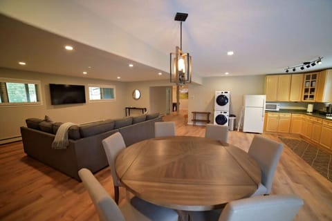 Lower level living room, kitchen, and dining including a secondary washer and dryer.