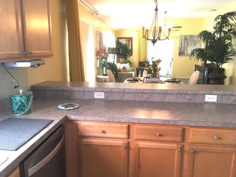 View from Kitchen to Dining Area and beyond. Patio access to the left with BBQ.