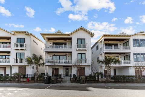 Modern coastal townhomes with balconies and palm trees.