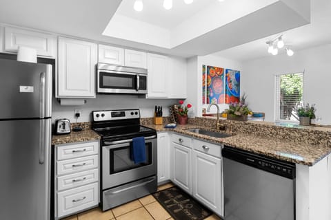 Kitchen with blender, toaster microwave, pots, spices, oil