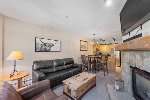 Sink into plush leather seating by your cozy stone fireplace, where rustic charm meets modern comfort in this inviting open-plan retreat.