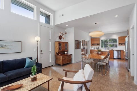 Our home is a custom, open floor plan. The living room opens up to a gorgeous custom kitchen space with extremely unique details like the giant mid-century modern dining table hanging light.