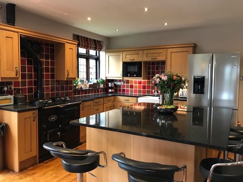 The huge kitchen/diner hosts a  central granite island ideal for informal dining