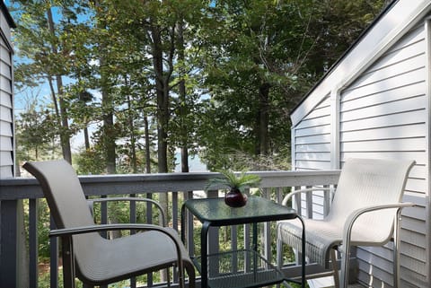 The balcony offers a table for two with a serene view of the lake.