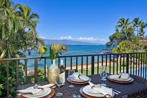 Enjoy meals on a private balcony overlooking turquoise waters and palm trees