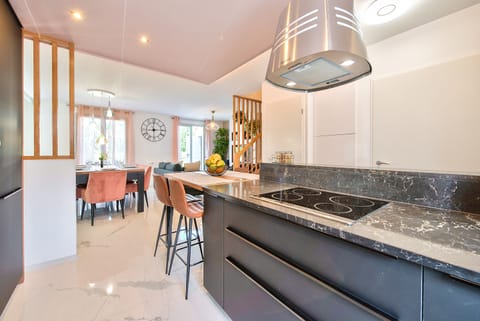 A fully equipped kitchen with a dining area and 4 high chairs, a refrigerator, 