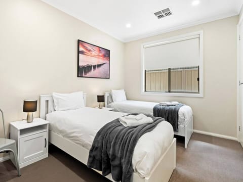 Bedroom 2  with comfy pillowtop mattresses and white linen fitted. Block out roller blind and large wardrobe. Bed and bath linen hire included. Colours of linen will vary.