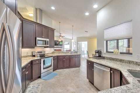 Marble countertops and floor-to-ceiling cabinetry.  Windows overlook pool area.