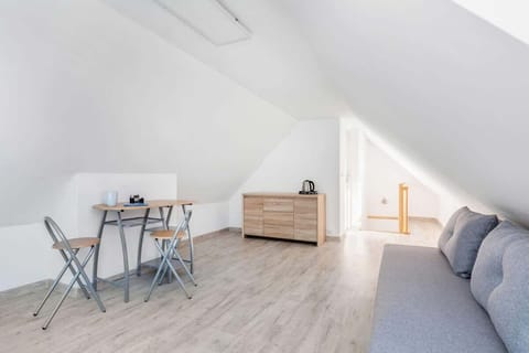 A modern living room with a gray sofa, a small wooden coffee table, and a minimalist white design.