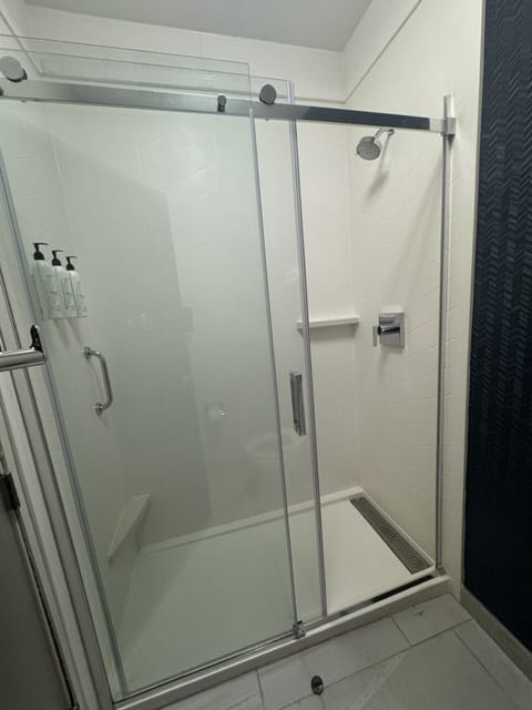 Shower, designer toiletries, hair dryer, towels