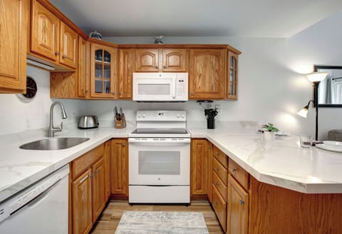 Your fully equipped kitchen features warm wood cabinetry, white appliances, and granite countertops with everything you need to prepare meals during your stay.