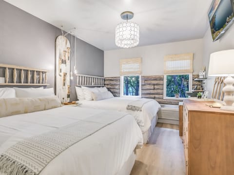 Two queen beds with fresh linens in Tranquility Suite, a quiet downtown Wimberley cabin