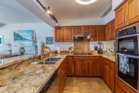 Well-equipped kitchen with cherry cabinetry and granite countertops.