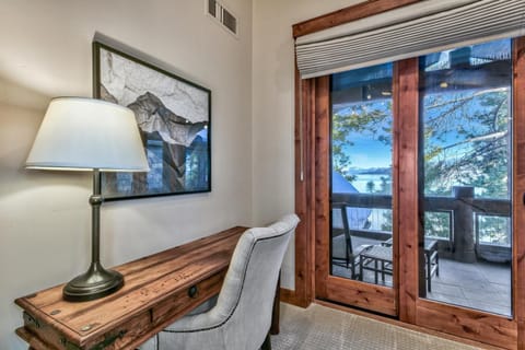 The primary bedroom has a desk and chair with views of the lake