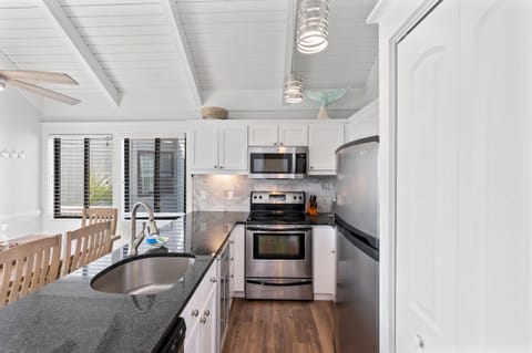 Kitchen open to dining area and living room with access to porch