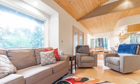 The living room is open to the dining and kitchen with lots of large windows.