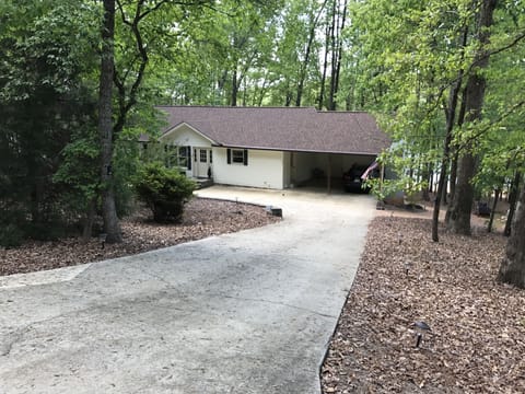 Front of house with car port for 2 cars and additional parking at front of house