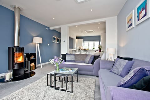 Cosy lounge with wood burner, sofa and coffee table in - Blue Bay