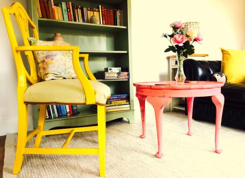 Cosy living area with vibrant, up-cycled furniture and stocked with books/games.