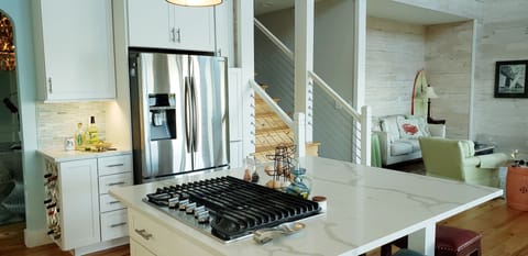 Stove top with refrigerator pictured w/wine rack.  Island seats 4