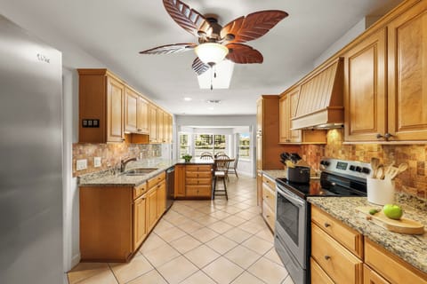 Open kitchen with wood cabinetry and stainless appliances.
