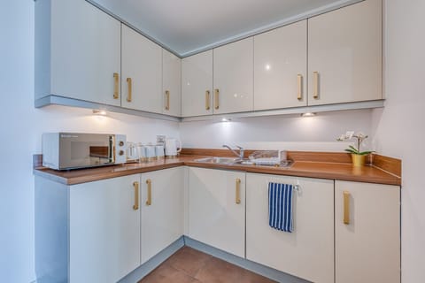 The apartment features a well-equipped kitchen complete with a dishwasher, fridge freezer, oven, stove, microwave, kettle, toaster, cookware, tableware, and utensils are all provided.