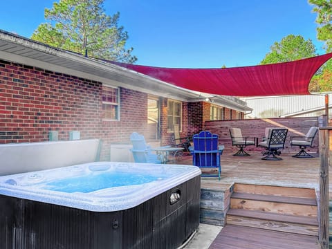 Soak in the 6-person hot tub, enjoying the serene wooded backyard views.