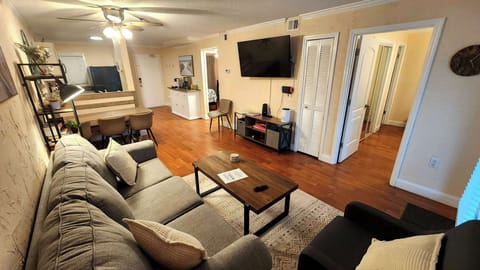 Open living space with smart TV, modern furnishings, and fold-out sofa bed.