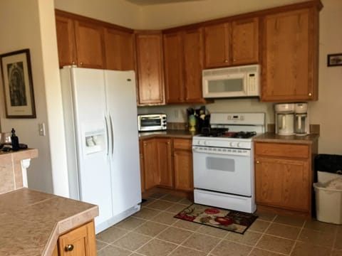 Gas oven/range and large refrigerator with water and ice in the door.