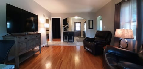 Open concept living. A third chair has been added by the lamp. 