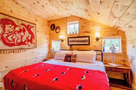 [Primary Bedroom, Upstairs] Secluded at the rear of the barn loft, this room unfolds a scene of southwestern charm, with ample lighting and window views of the animals in the pasture.
