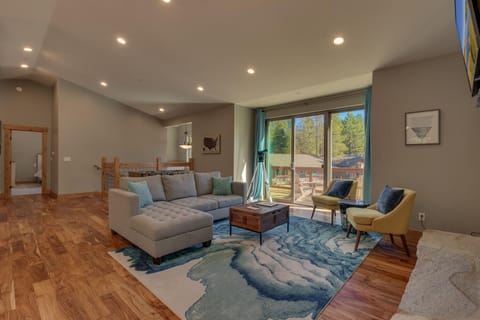 - Spacious living room with modern design  
- Large windows bring natural light and forest views  
- Comfortable seating for gatherings in Tahoe