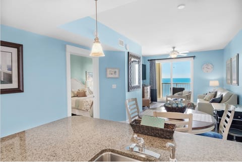 Your open kitchen flows into a bright living space where stunning ocean views through glass doors create the perfect coastal retreat.