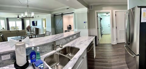 Kitchen with stainless steel appliances and prep island with seating. Dunescape 101 IOP Escapes