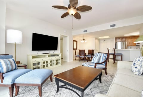 Your spacious living area flows seamlessly into the dining space, with coastal-inspired furnishings and modern entertainment creating the perfect retreat atmosphere.