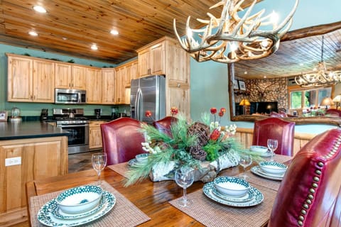 Dine at the large farmhouse-style table with seating for six under warm wood-paneled ceilings.