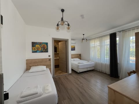 Triple Room, Balcony, Garden View | Minibar, laptop workspace, soundproofing, iron/ironing board
