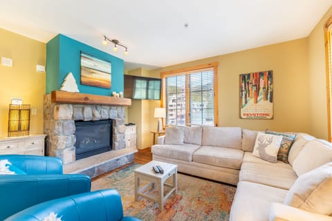 Sink into plush sectional seating by your stone fireplace, where warm colors and ski lodge charm create the perfect après-ski retreat.