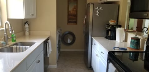 Galley kitchen with stainless steel appliances. Washer and dryer and pantry.